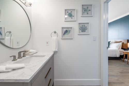 Un baño blanco con lavabo y espejo. en Sunset Suite Skyline Views King and Twin Sofa Includes Parking, en Miami