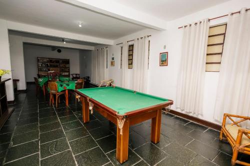 a room with a pool table and some chairs at Suíte no Centro de Caxambu - Poucos metros do Parque in Caxambu