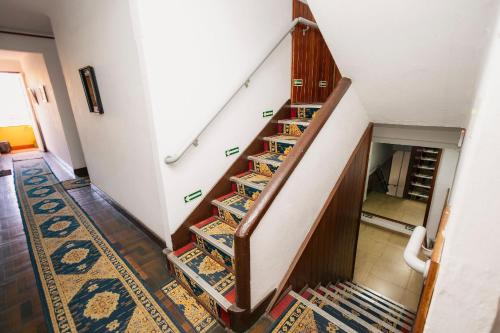 a staircase with bookshelves in a house at Suíte no Centro de Caxambu - Poucos metros do Parque in Caxambu
