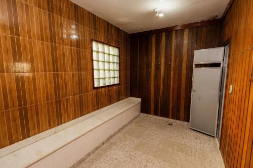 an empty room with a refrigerator and a window at Suíte no Centro de Caxambu - Poucos metros do Parque in Caxambu