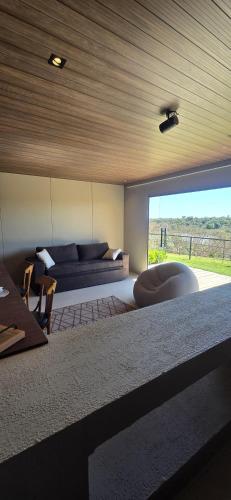 ein Wohnzimmer mit Couch und großem Fenster in der Unterkunft Bangalô Kyalami Wake Park in Várzea Grande