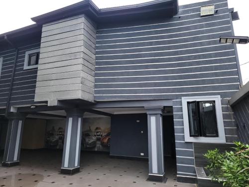 a house with a black door and a porch at Caesar's Hotel & Apartment Room 13 in Ikeja