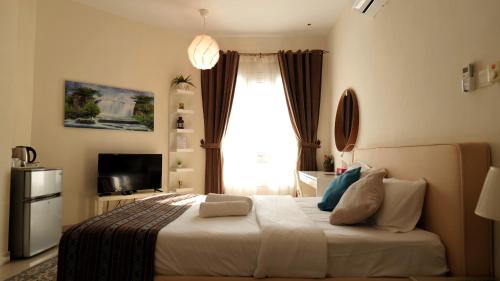 a bedroom with a large bed with a window at Royal Suites Muscat in Ma‘ābīlah