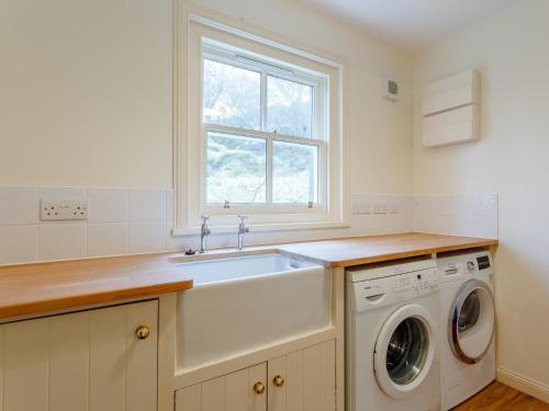 a kitchen with a sink and a washing machine at 3 bed in Achnasheen CA120 in Inveralligin