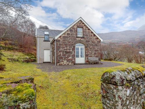 a stone house on a hill with a stone wall at 3 bed in Achnasheen CA120 in Inveralligin