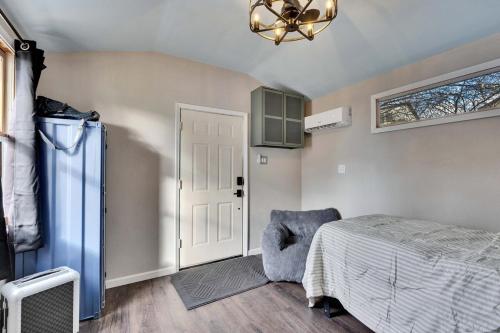 a bedroom with a bed and a chair and a chandelier at Walkable Private Guest House Studio with Pickleball Court in Austin