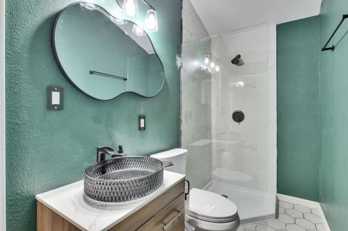 a bathroom with a sink and a toilet and a mirror at Walkable Private Guest House Studio with Pickleball Court in Austin