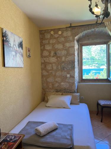 a bedroom with a bed and a stone wall at Tetka Apartments in Kotor