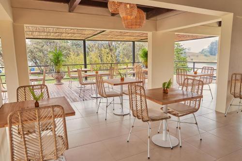 a restaurant with tables and chairs with a view at La Pausa Hotelbistro in Guatapé