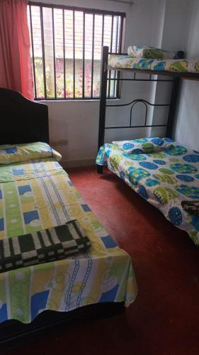 a room with two bunk beds and a window at Finca Las Hamacas- La Posada del pensamiento in Santa Beatríz