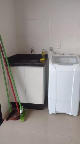 a kitchen with a sink and a washing machine at Ed Highline, piscina, lavanderia in Joinville