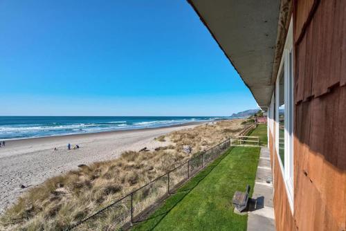 a view of the beach from the balcony of a beach house at Spacious Beachfront Suite - Sleeps 7 - Second Floor - Pool and Sauna in Lincoln City