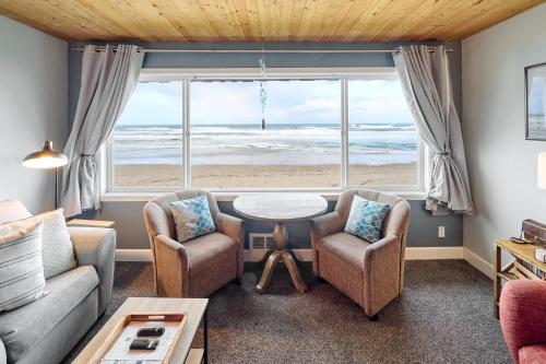 a living room with a view of the beach at Spacious Beachfront Suite - Sleeps 7 - Second Floor - Pool and Sauna in Lincoln City