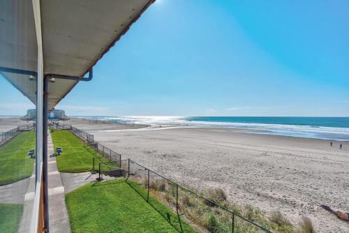 a view of the beach from the balcony of a beach house at Spacious Beachfront Suite - Sleeps 7 - Second Floor - Pool and Sauna in Lincoln City