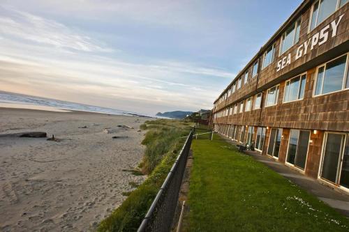 a building on the beach next to a beach at Spacious Beachfront Suite - Sleeps 7 - Second Floor - Pool and Sauna in Lincoln City