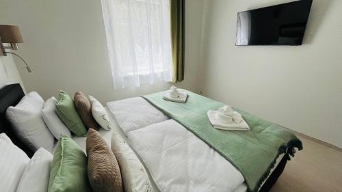 a bedroom with a bed with towels on it at Vitality Apartman in Makó