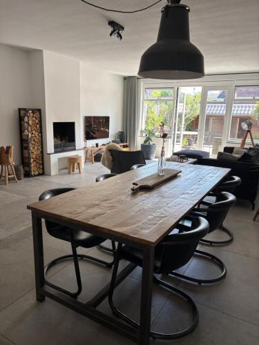a large wooden table in a living room with chairs at Wellness Villa Binnenhof in Noordwijk