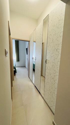 a hallway with mirrors in a hotel room at Vitality Apartman in Makó