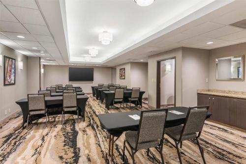 a conference room with tables and chairs and a screen at Drury Inn & Suites Atlanta Morrow in Morrow