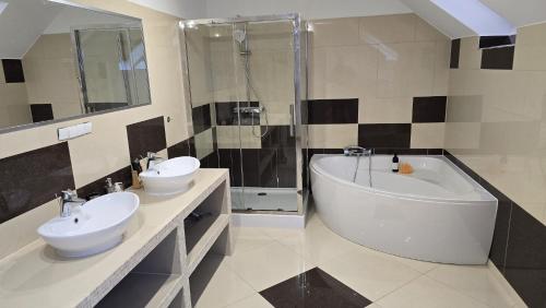 a bathroom with a tub and two sinks and a bath tub at Willa na Ogrodowej in Długopole-Zdrój