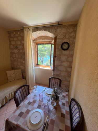 a dining room with a table and chairs and a window at Tetka Apartments in Kotor