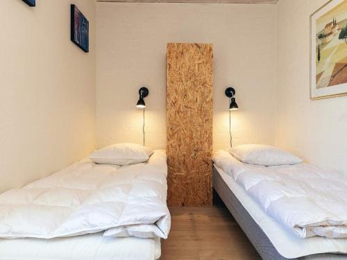 韦斯特维4 person holiday home in Vestervig的配有两盏灯的房间的两张床