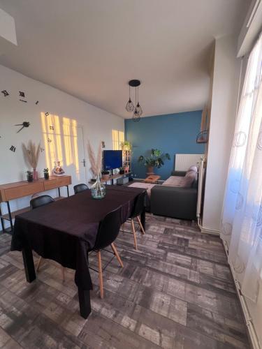 ルマンにあるChambre avec espaces communs-proche du circuit des 24hのテーブルとソファのあるリビングルーム