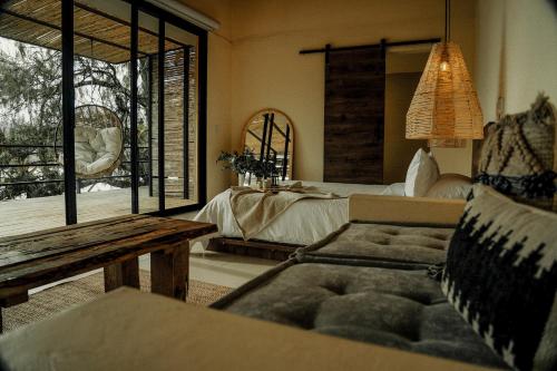 a bedroom with a bed and a couch and a window at La Pausa Hotelbistro in Guatapé