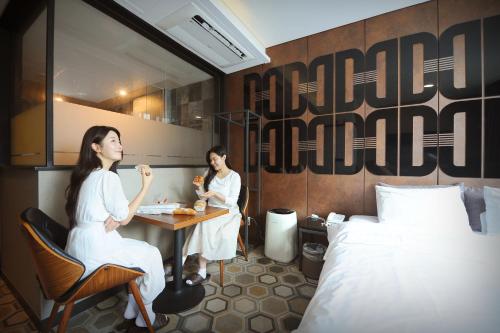 two women sitting at a table in a hotel room at K Boutique Hotel in Yeosu