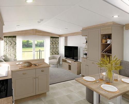 a large kitchen with a table and a living room at DJD ,Country Style Luxury Lodge, Manor Park Sleeps 4 in Hunstanton