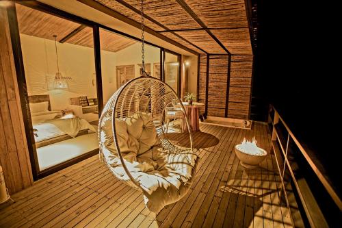 a swinging chair on a balcony with a bedroom at La Pausa Hotelbistro in Guatapé