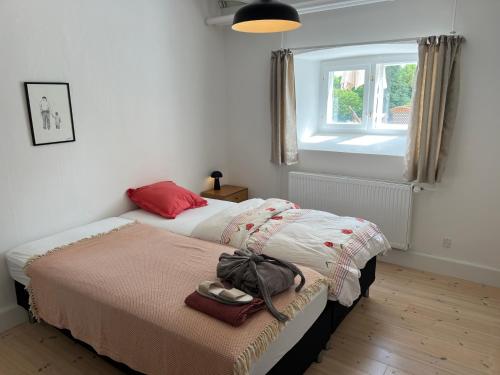 two beds in a small room with a window at Hesede Hovedgård in Haslev