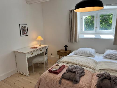 a bedroom with two beds and a desk and a window at Hesede Hovedgård in Haslev