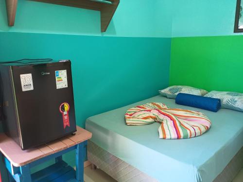 a small bed in a room with a green wall at Pousada Primavera in Bonito