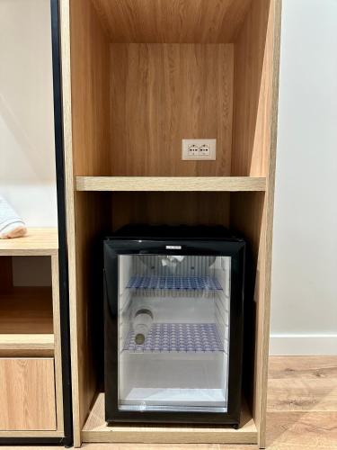 a cabinet with an empty refrigerator in a room at Hotel Relax City Center in Tirana