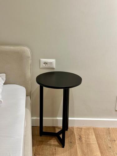 a black table in a room next to a bed at Hotel Relax City Center in Tirana