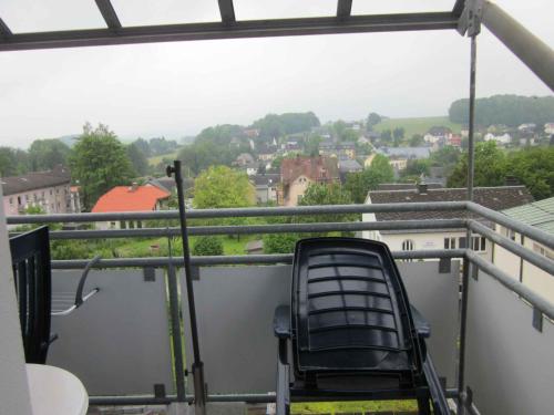 a chair on a balcony with a view of a city at Apartment in Bad Steben - Bayern 50803 in Bad Steben