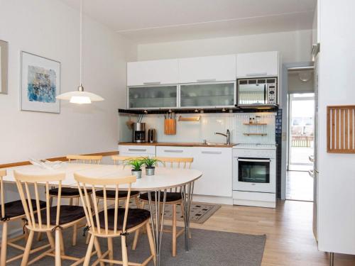 a kitchen with white cabinets and a table and chairs at Norddjurs Holiday Center in Glesborg
