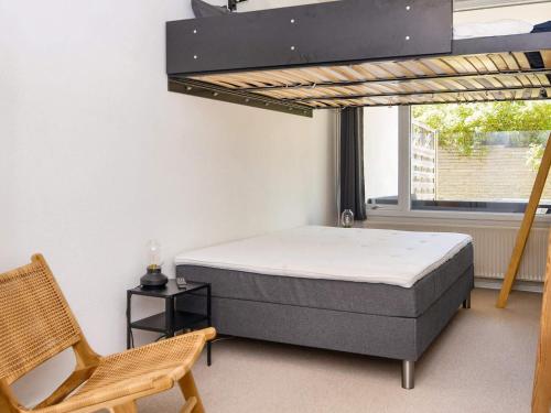 a bedroom with a bed and a chair and a window at Norddjurs Holiday Center in Glesborg