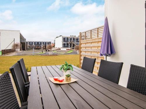 a wooden table with a plate of watermelon on a balcony at 4 person holiday home in Glesborg in Glesborg