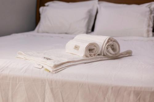 une pile de serviettes posée sur un lit dans l'établissement Apto Comfort Central (Perto de tudo), à São Lourenço