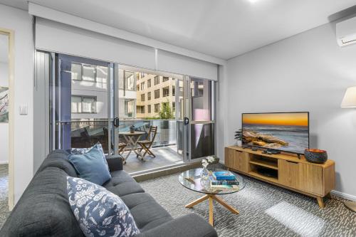 a living room with a couch and a tv at AAN Apartments North Sydney in Sydney
