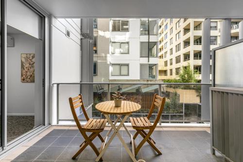 a table and two chairs on a balcony with a view at AAN Apartments North Sydney in Sydney