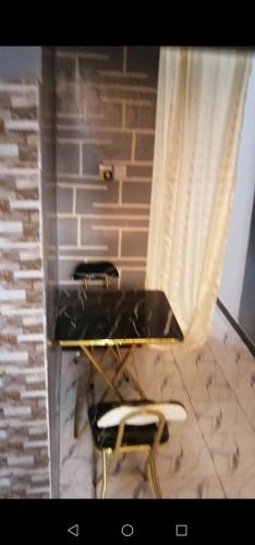 a table and two chairs in a room with a brick wall at CHEZ Mamadou et Binetou in Mbour