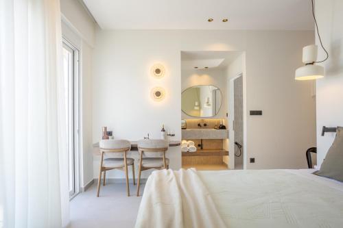 a bedroom with a bed and a table and a mirror at Eftihia Studios Paleochora in Palaiochóra