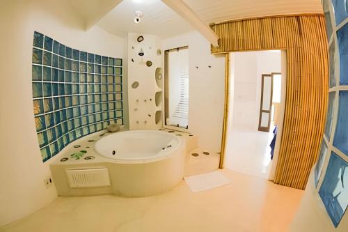 a bathroom with a large tub in a room at Casa Janaina Ilhabela in Ilhabela