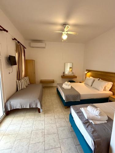 a bedroom with two beds and a ceiling fan at Eftihia Studios Paleochora in Palaiochóra