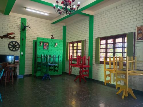 a room with green and red chairs and tables at Pousada Primavera in Bonito