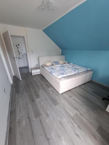 a bedroom with a bed and a wooden floor at Rodinný dům v klidném prostředí in Slavkov pod Hostýnem