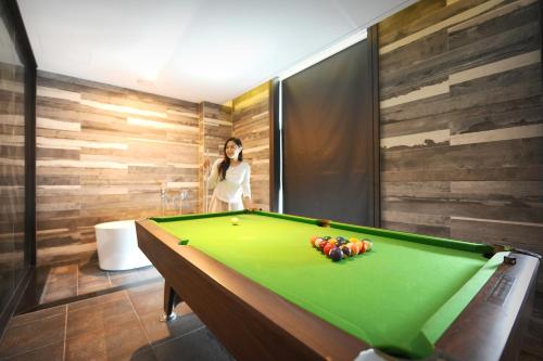 a woman standing next to a pool table at K Boutique Hotel in Yeosu